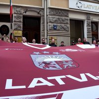 Foto: Latvijas hokeja fani pēc uzvaras Vecrīgā nodzied himnu pie Itālijas vēstniecības