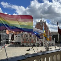 Pie Rīgas domes izkārts LGBTQ karogs; divas partijas neapmierinātas