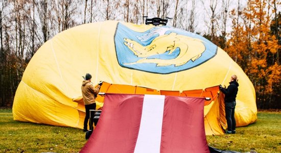 Video: Sveicot Latviju simtgadē, virs Lietuvas ar gaisa balonu tika pacelts Latvijas karogs