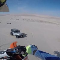 Video: Motokrosists lēcienā pār tuksneša kāpu negaidīti piezemējas uz džipa