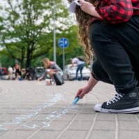 Foto: Jaunieši Jūrmalā uz asfalta raksta Raiņa un Aspazijas dzeju