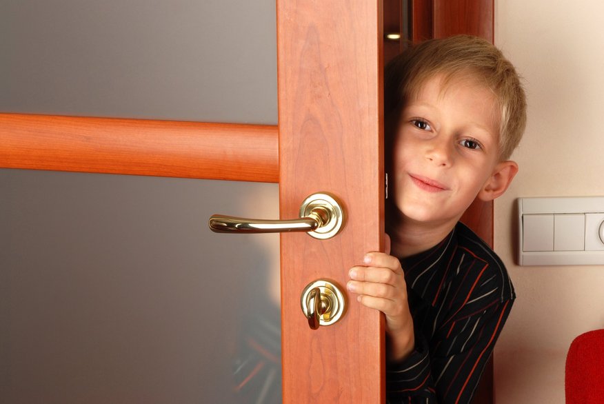 Мальчик и дверь открылась. Мальчик выглядывает из двери. Выглядывает из за двери. Мальчик выглядывает из за двери. Ребенок за дверью.