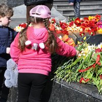 Foto: Amatpersonas un iedzīvotāji noliek ziedus pie mūžīgās uguns Daugavpilī