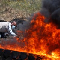 Foto: Melnos riepu dūmu mutuļos palestīnieši protestē pret vēsturisko zemju atņemšanu
