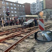 Foto: Remontdarbu vietā iestrēdzis 'Mercedes' uz laiku bloķē tramvaju satiksmi