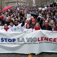 Foto: Parīzē 'sarkanie lakatiņi' protestē pret 'dzelteno vestu' vardarbību